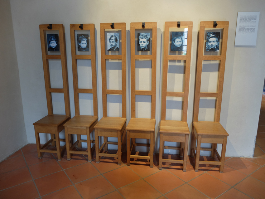 dans le hall les chaises portemanteaux avec les portraits de leurs occupants